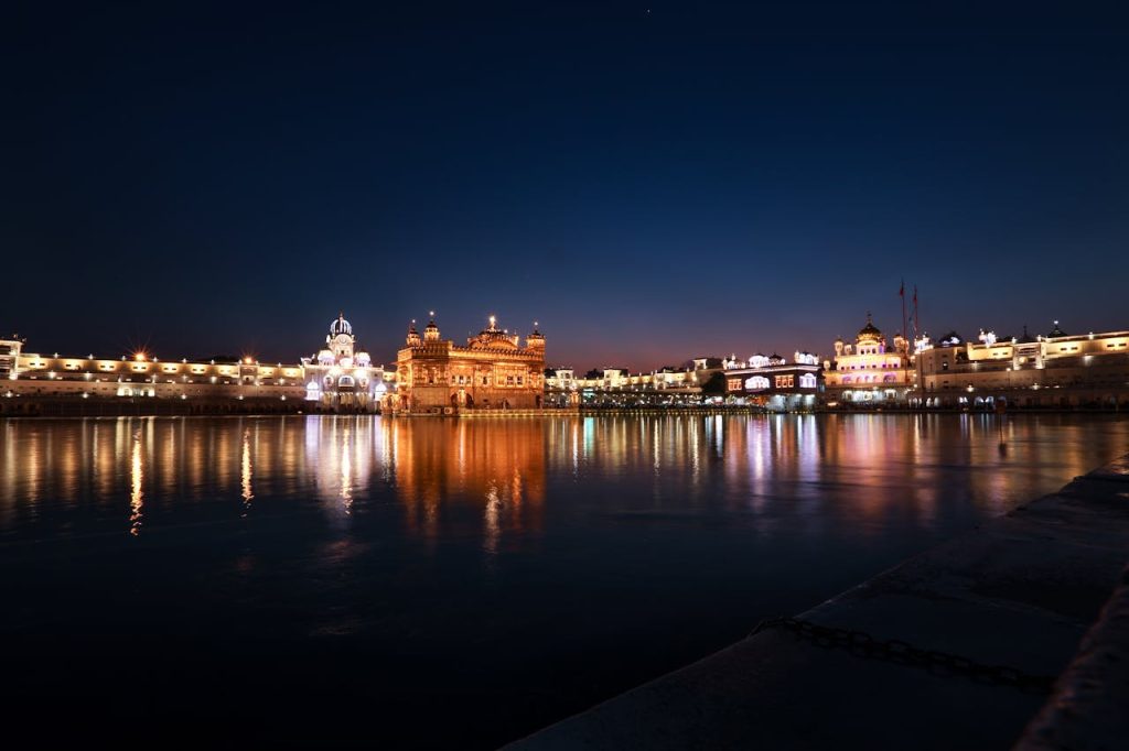 River bank with illuminated ancient temples in dark